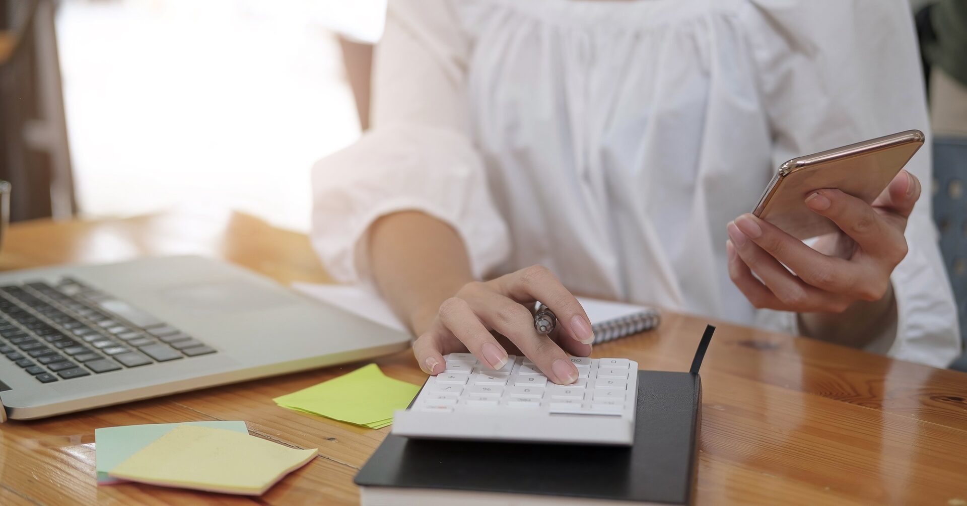 Close up cropped of woman using smartphone, calculating bills, browsing online banking service